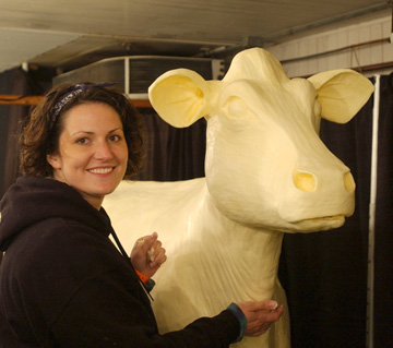Butter sculptor Sarah Pratt and a butter cow from the Iowa State Fair