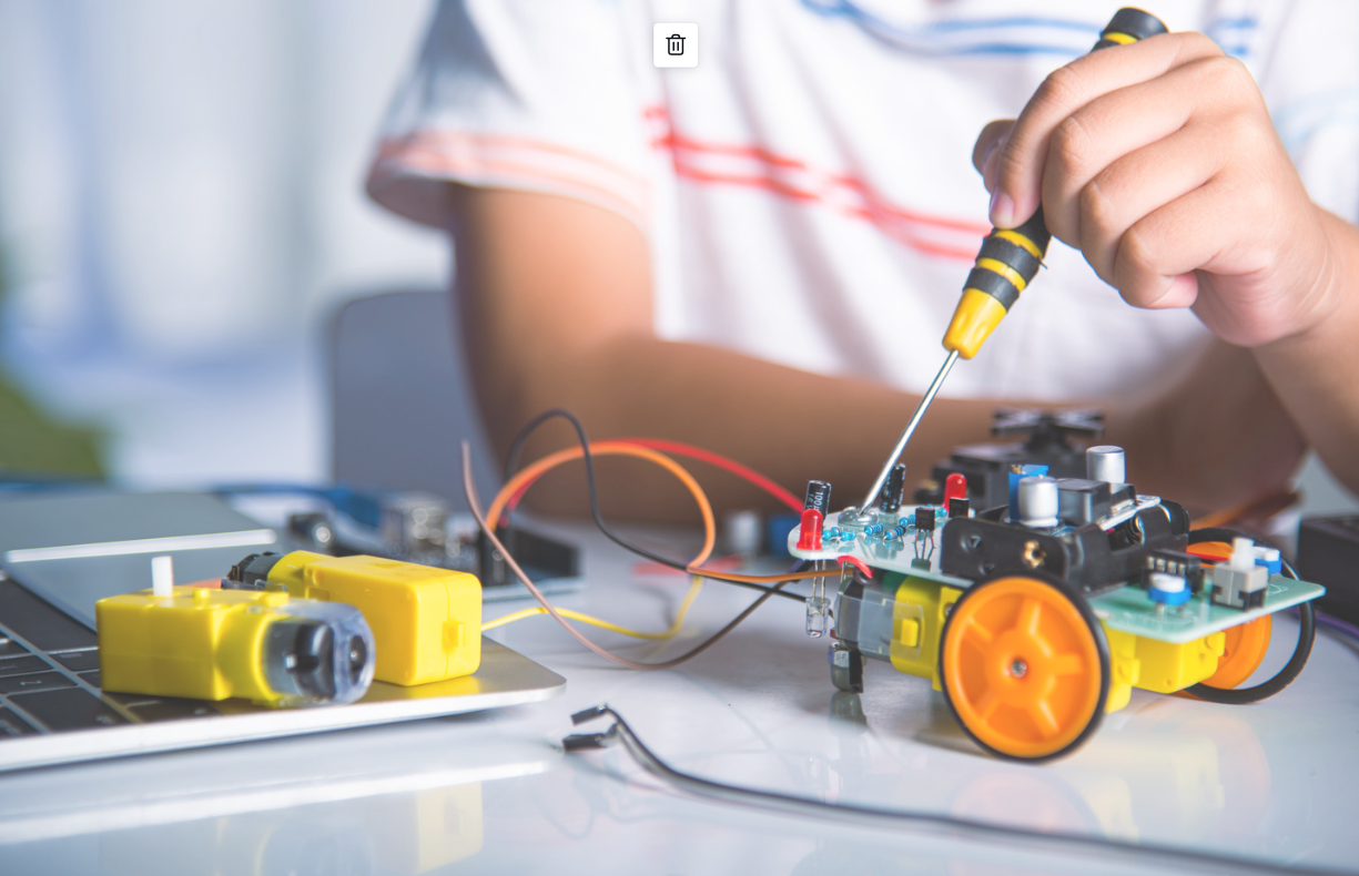 Young person soldering a machine robot
