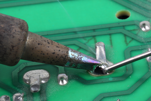 close up of circuit board and soldering iron 