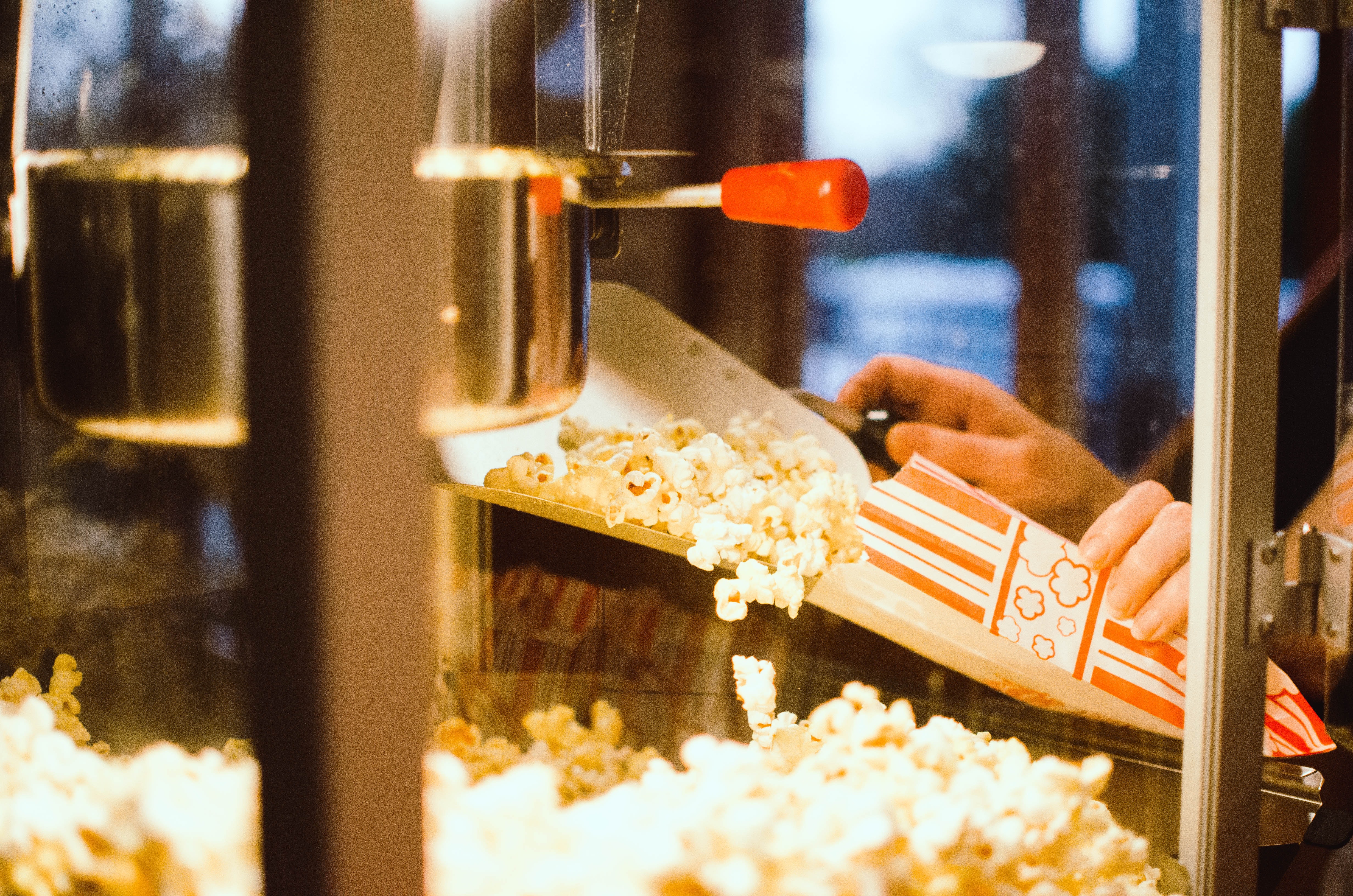 Photo of hands scooping popcorn into a bag