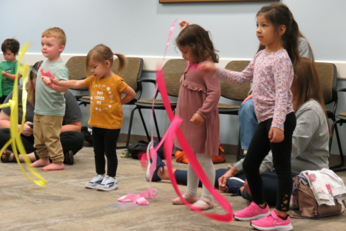 A group of kids dancing with ribbons.
