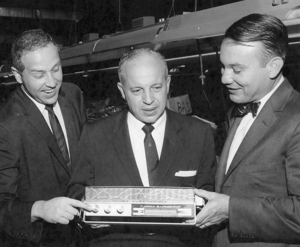 Photo of Owen Meyerson and Leo Meyerson of Globe Electronics showing George William Miller a new-type radio broadcasting set which can be used by untrained operations.