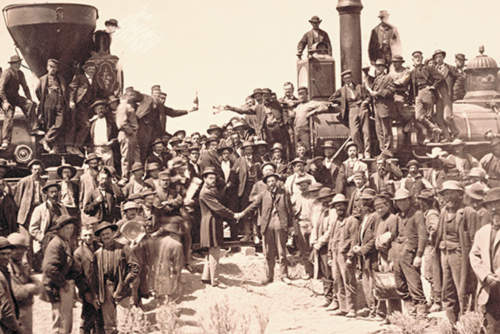 Sepia image of two trains running parallel and a lot of men surrounding the trains