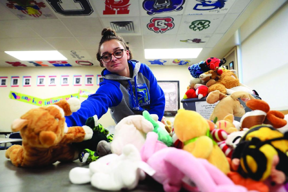 Photo of Abraham Lincoln high school student boxing stuffed animals to be shipped to Karadah, Baghdad, Iraq.  