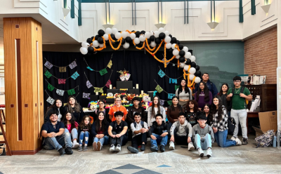 A photo of the class Spanish for Spanish Speakers from TJ High School in front of the community ofrenda they built at the library. 