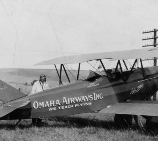 Andy Nielsen standing by a bi-plane