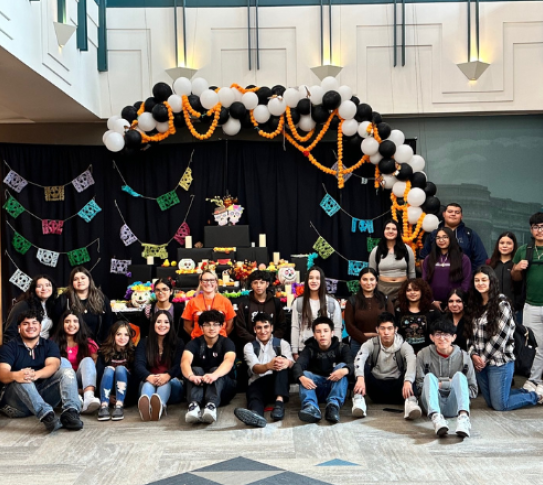 A photo of the class Spanish for Spanish Speakers from TJ High School in front of the community ofrenda they built at the library. 