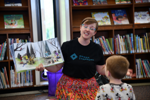 Person reading a book to a child.