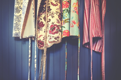 several aprons hanging against a wall