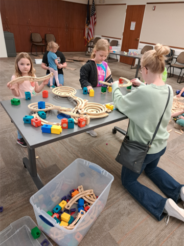 Adult and children building a marble run.