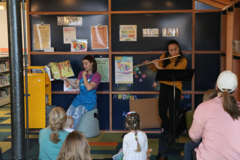 Librarian reading a book with a flute player.