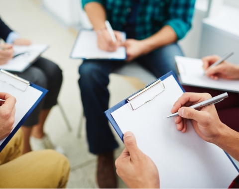 group of people with clipboards ready to write on