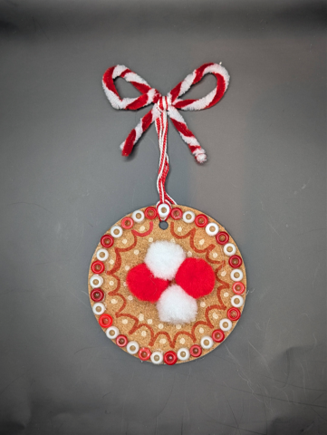 Charm decorated with red and white poms and beads