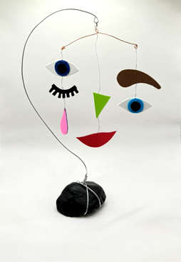 Facial features hanging on wire.