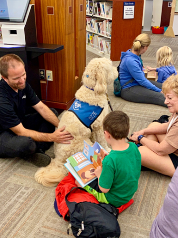 Child reading to a dog.