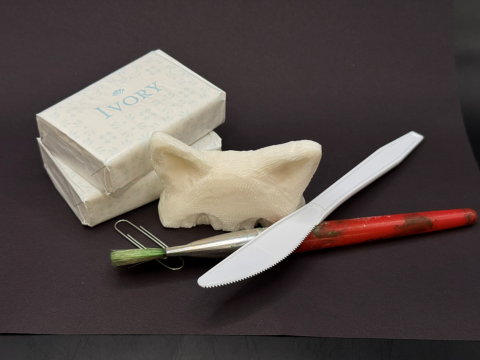 Cat carved out of soap, paintbrush and plastic knife.