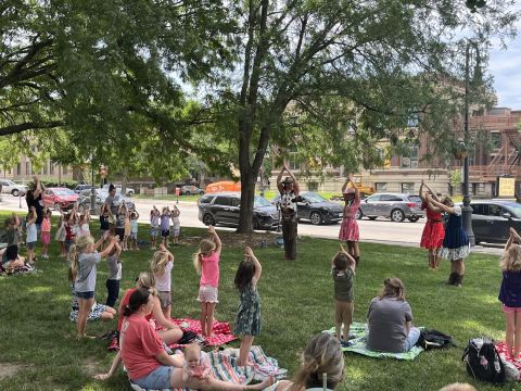 Ballet dancers teaching children a story dance.