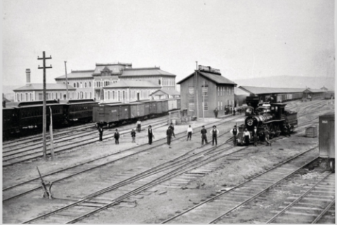 Photograph showing railroad employees at a Council Bluffs Transfer Hotel, rail yard and depot in 1877-78. 