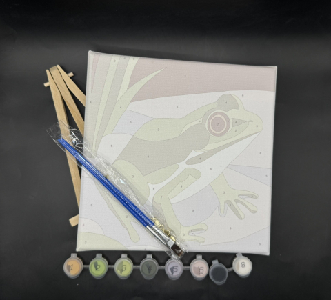 Paint brush, paints, frog on a canvas and an easel.
