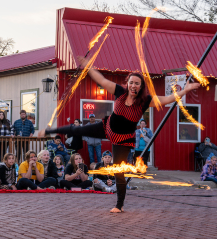 A woman spinning hula hoops on fire.