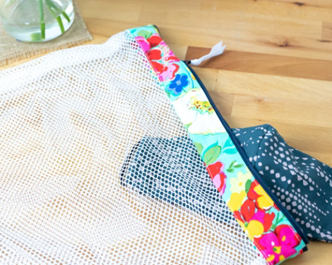 A mesh wash bag with a small item inside.