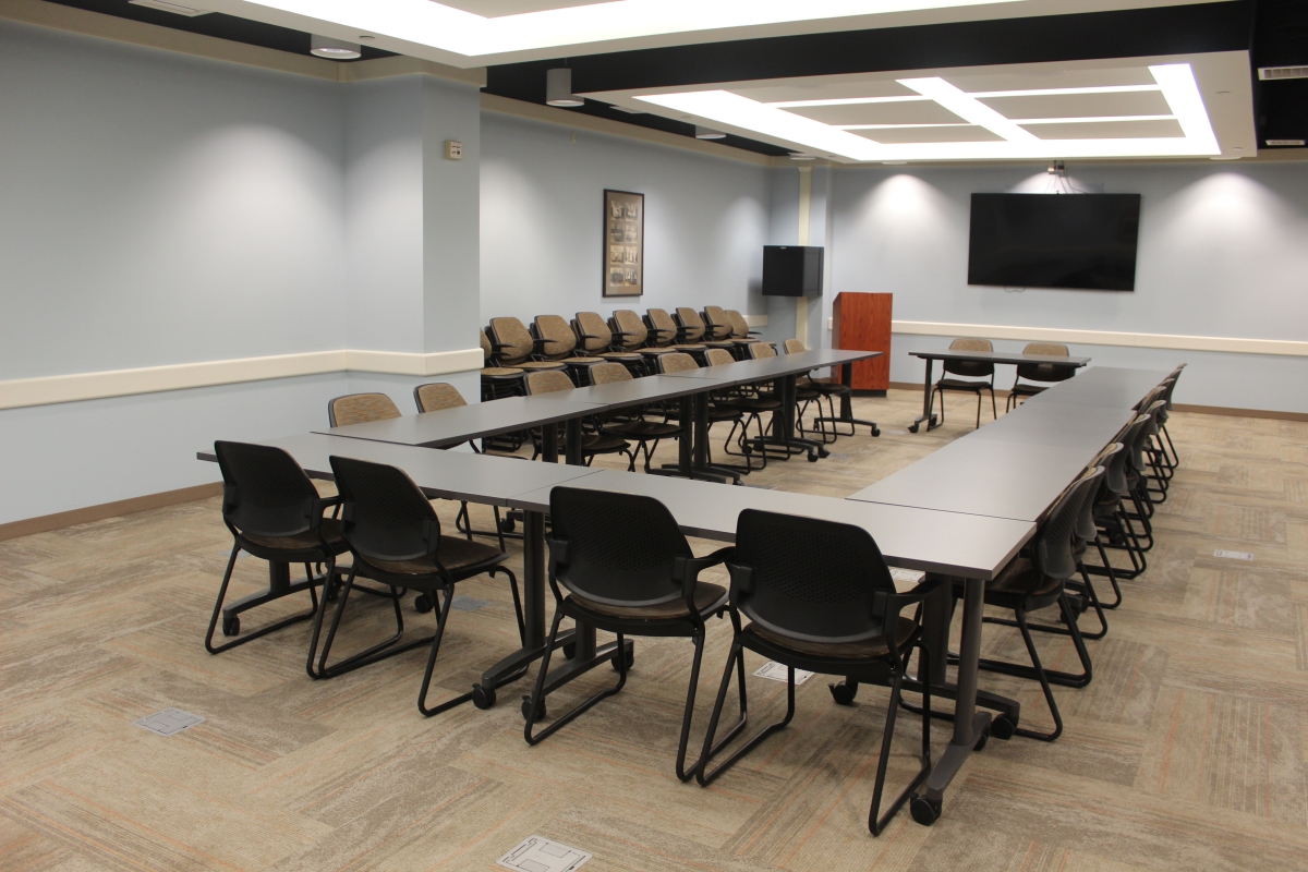 Eleven tables set up in a u shape with chairs surrounding