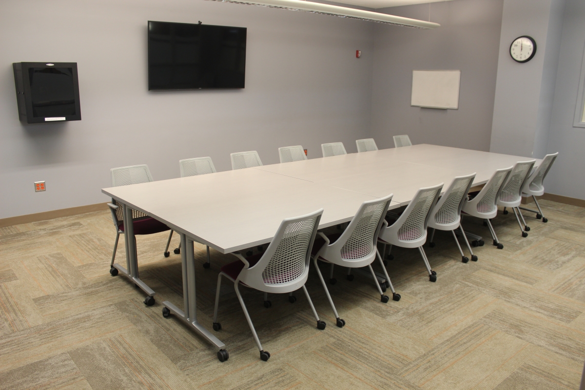 Six tables arranged to form one large table with fourteen chairs surrounding