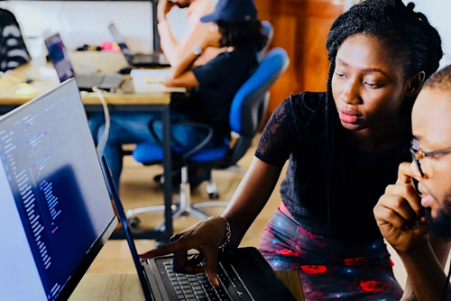 Woman helping man at computer