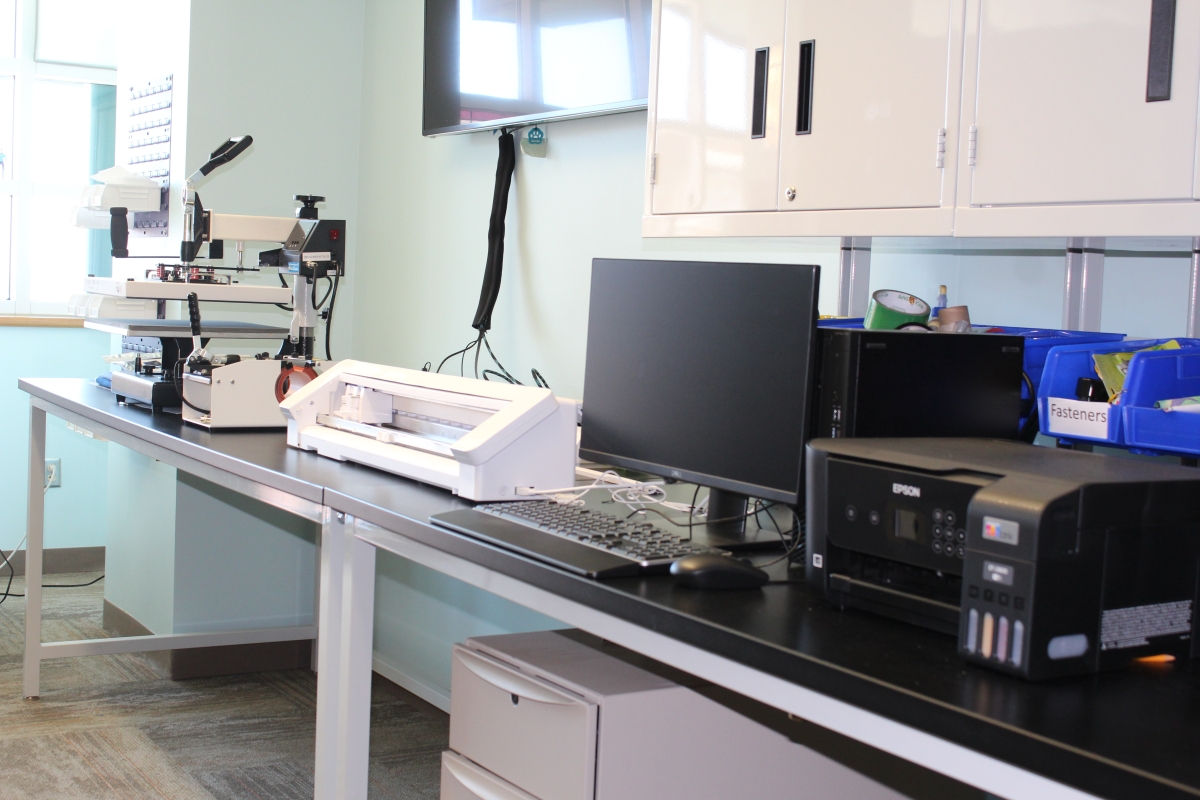 Heat Press, Cameo, computer, and printer arranged on a table