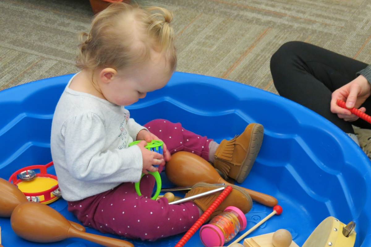 Child sitting in a pool of instruments.