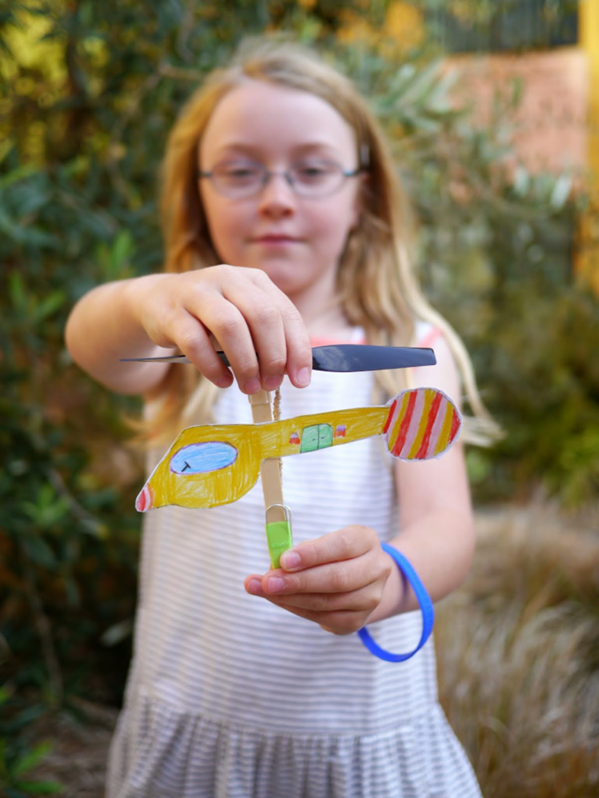 Child with a rubberband helicopter.