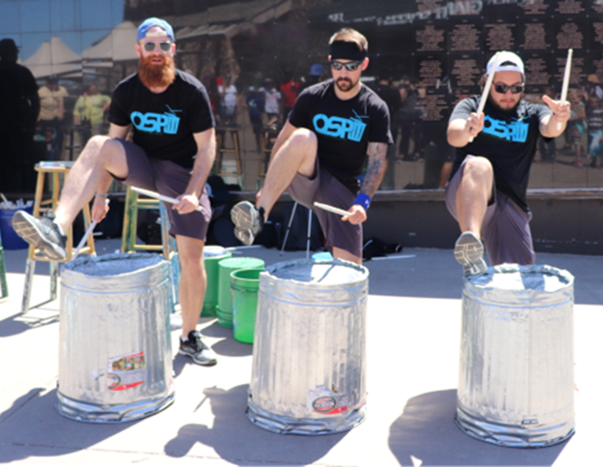 Men drumming on garbage cans.