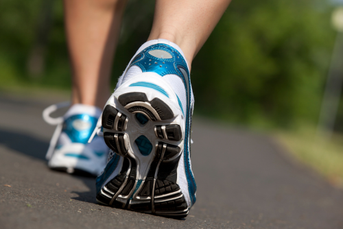 close up on shoes of someone walking on paved path
