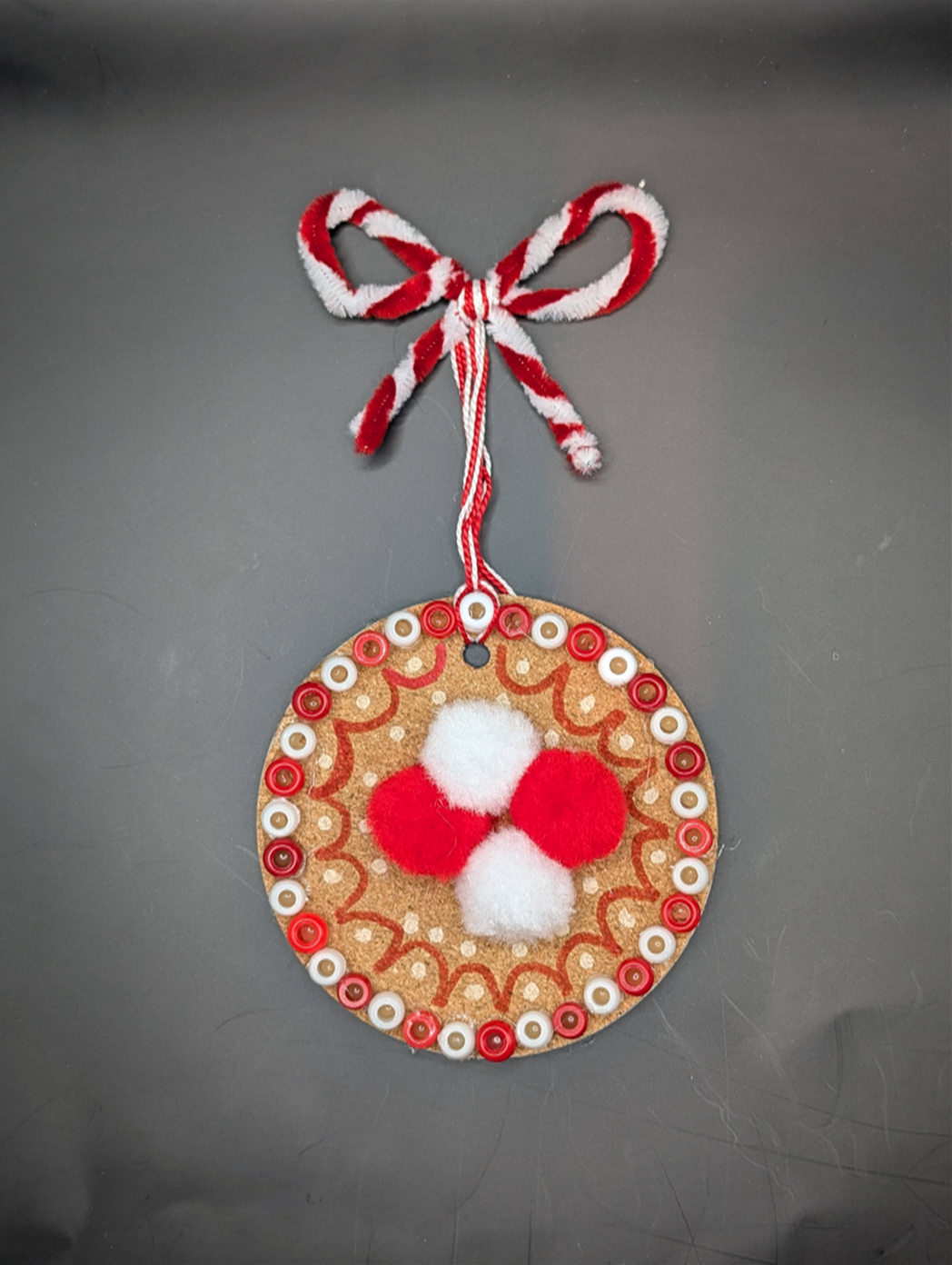 Charm decorated with red and white poms and beads
