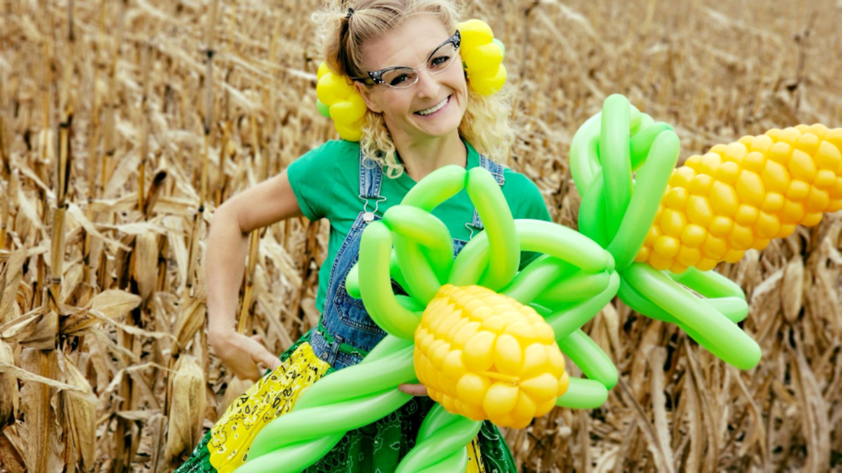 Woman holding corn balloons.