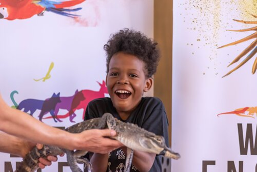Child holding alligator. 