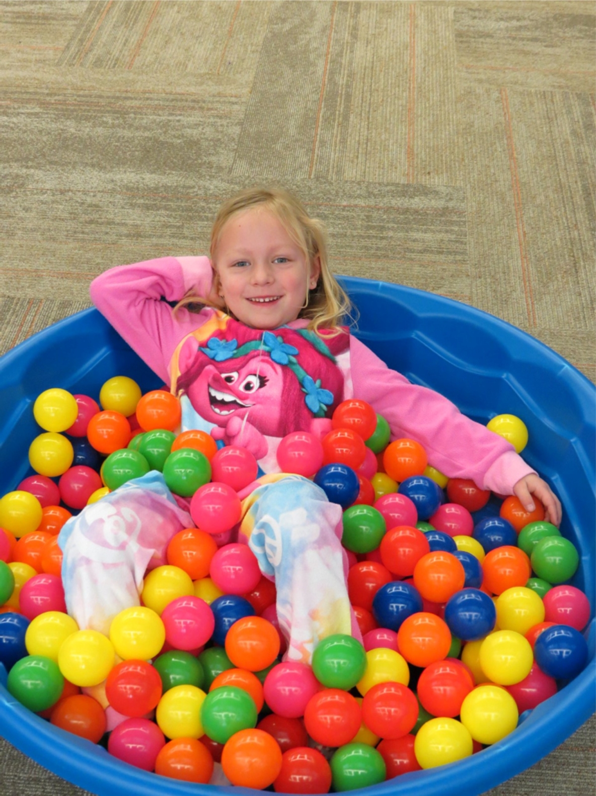 Girl in her jammies in a ball pool.