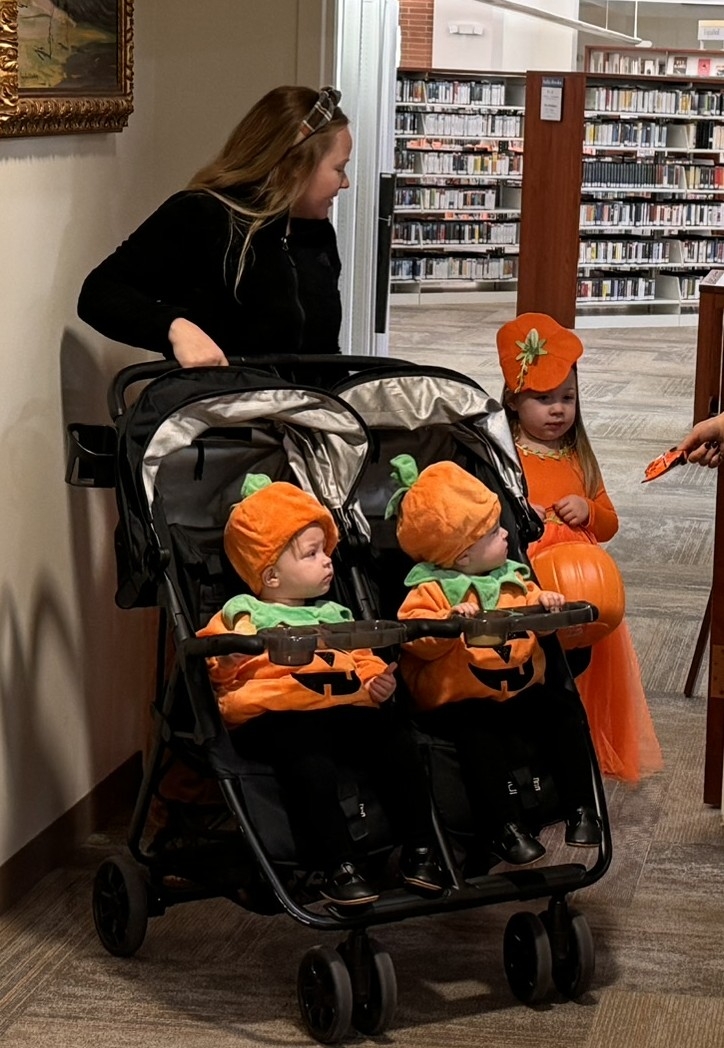 Children dressed as pumpkins getting candy.