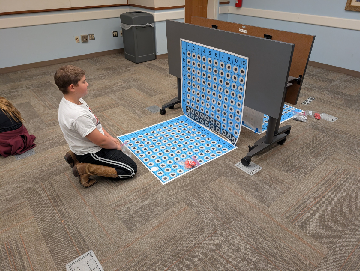 Children playing large sized battleship game.