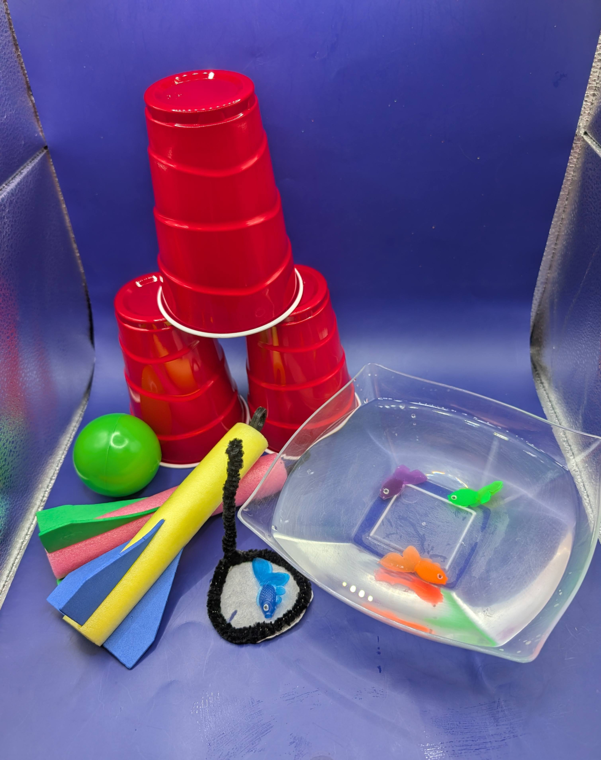 Red cups, foam rocket and plastic fish in a bowl.