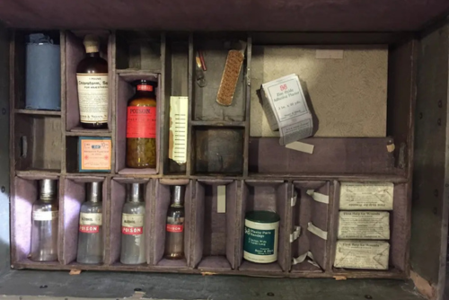 old medicine cabinet displaying bottles and medical tools