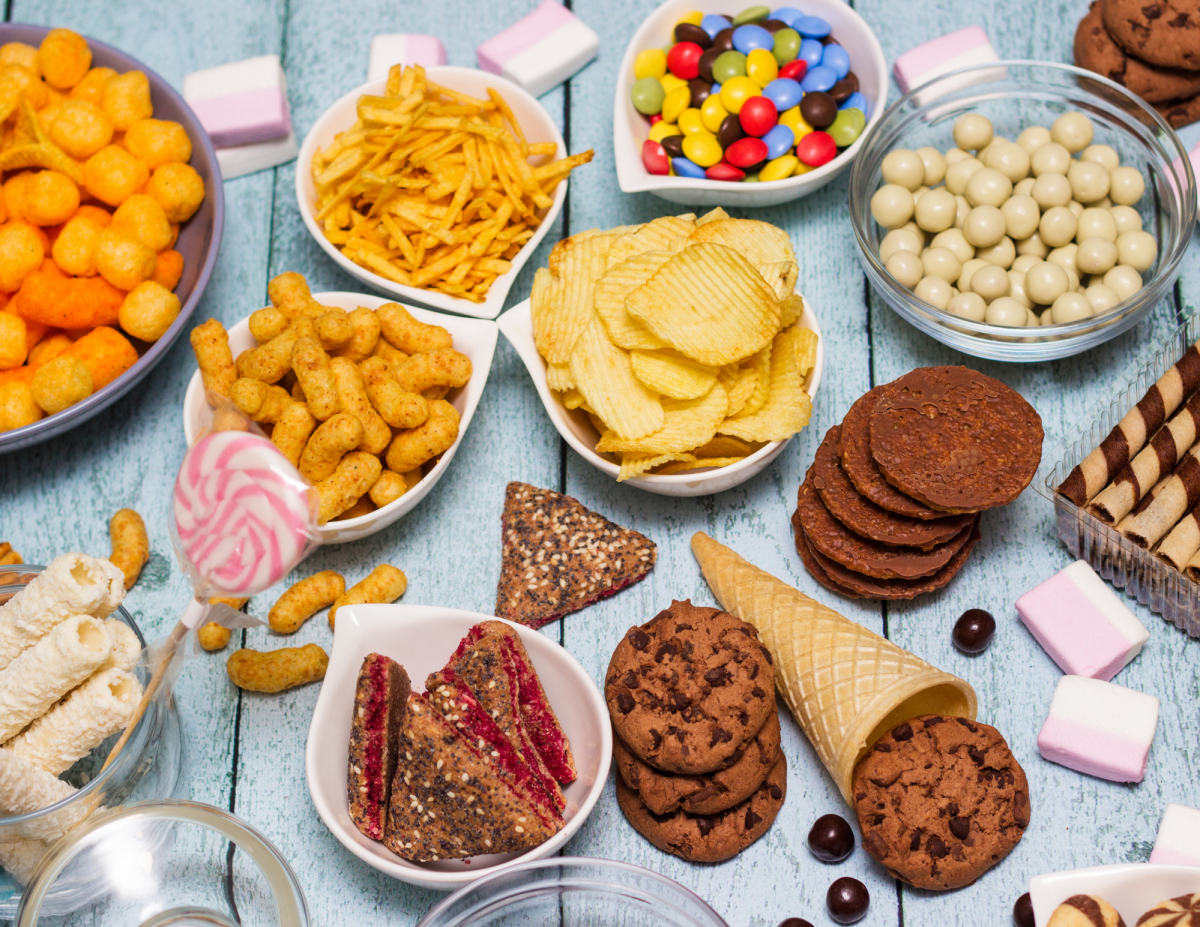 A table with snacks, such as chips, cookies, and candy.