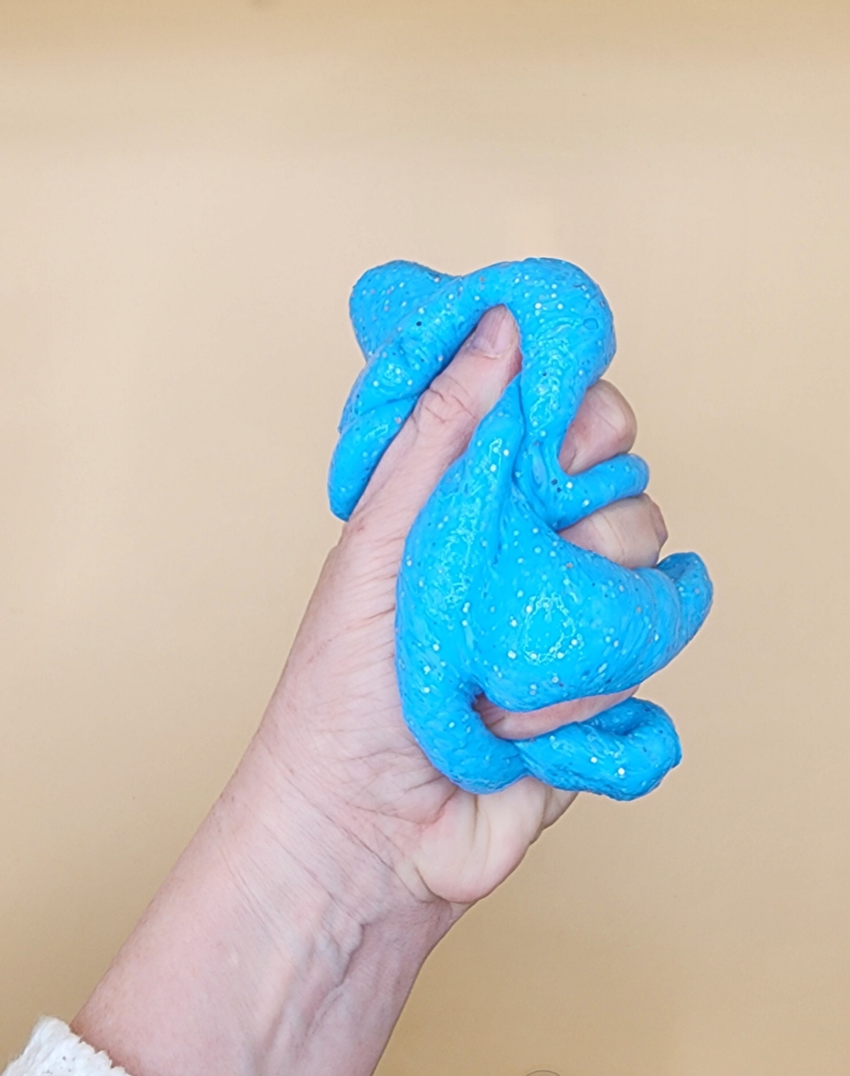 A hand holding slime.