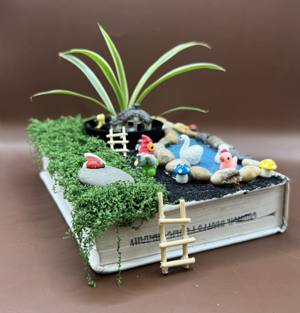 Book made into a planter with a gnome scene.