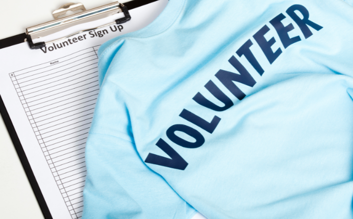 blue volunteer t-shirt and sign-up sheet on clipboard